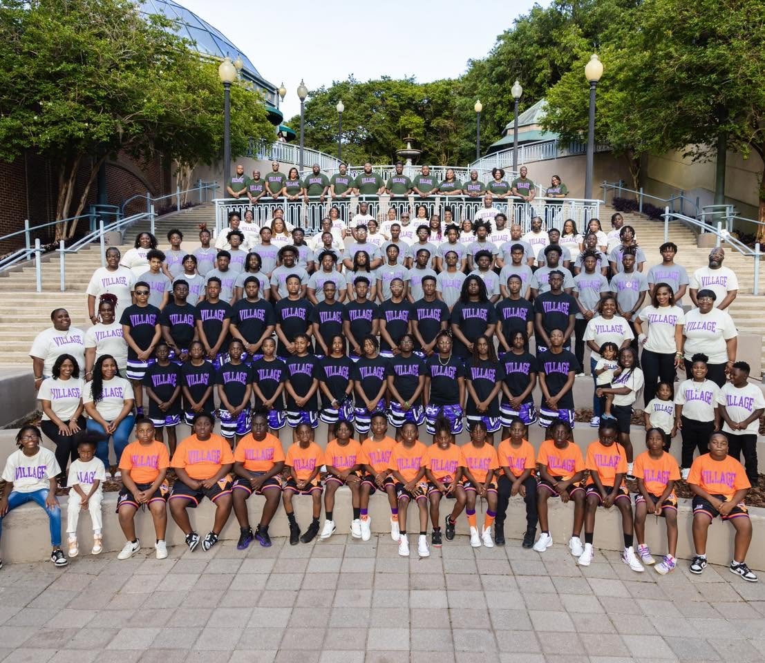 The Lamplighter community wearing Village shirts on outdoor steps.